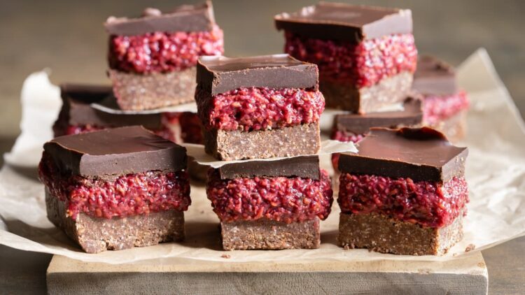 Chocolate raspberry chia slice displayed on a sheet of baking paper