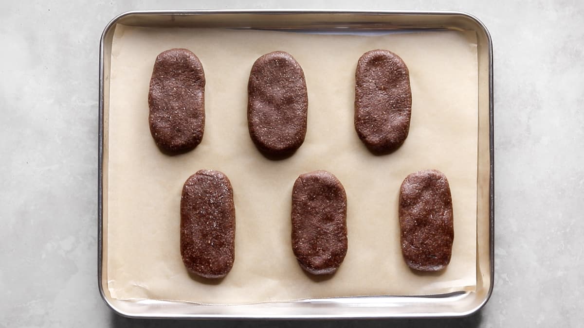 Chocolate protein bar dough shaped into bars on a parchment-lined tray