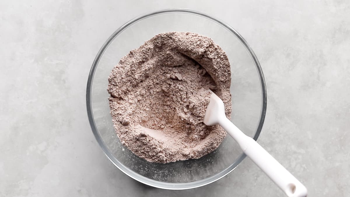Dry ingredients for protein bars mixed together in a bowl with a spatula