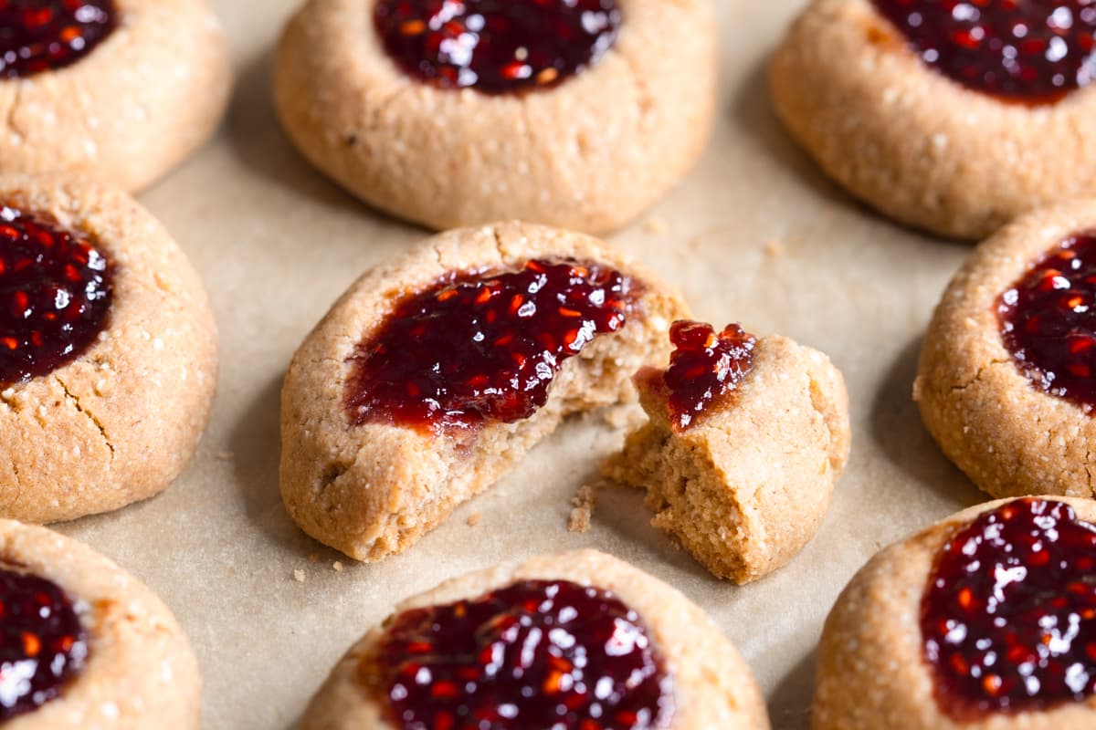 Gluten-free buckwheat jam thumbprint cookies baked on a tray lined with baking paper