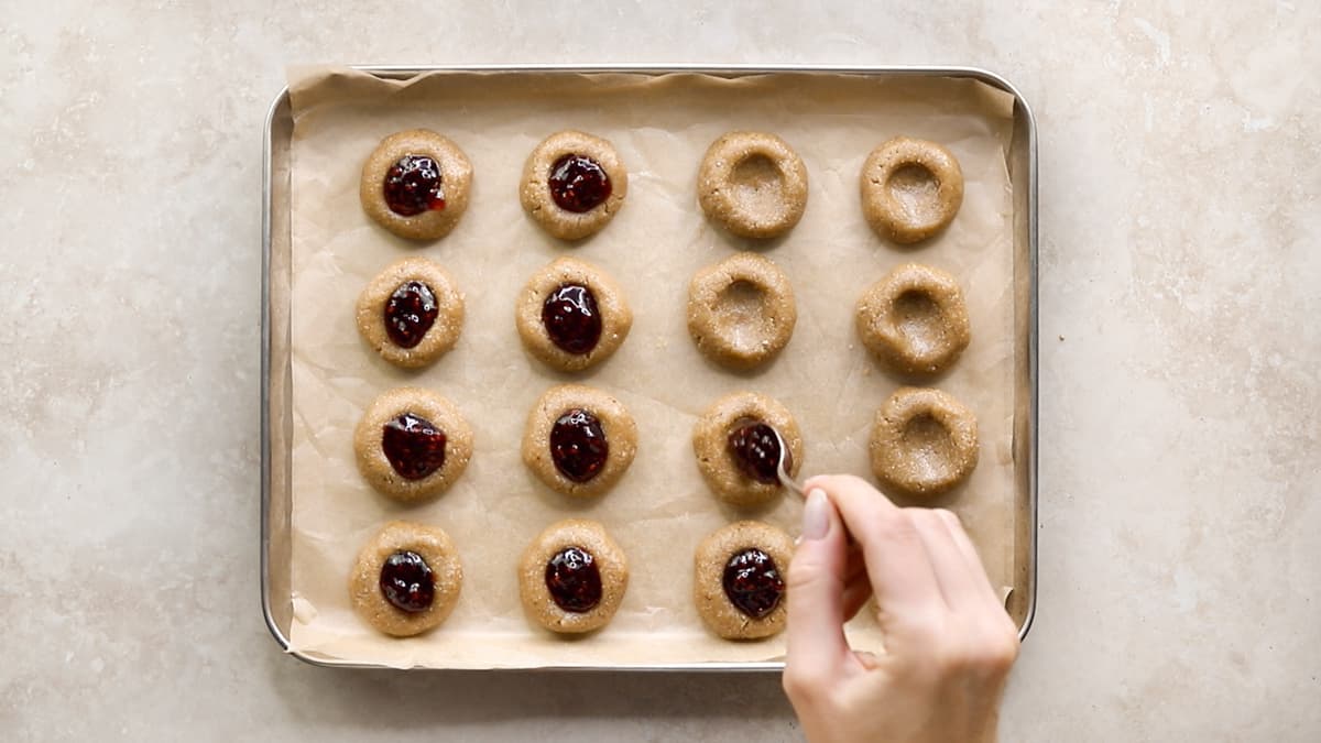 Fill each thumbprint cookie with jam