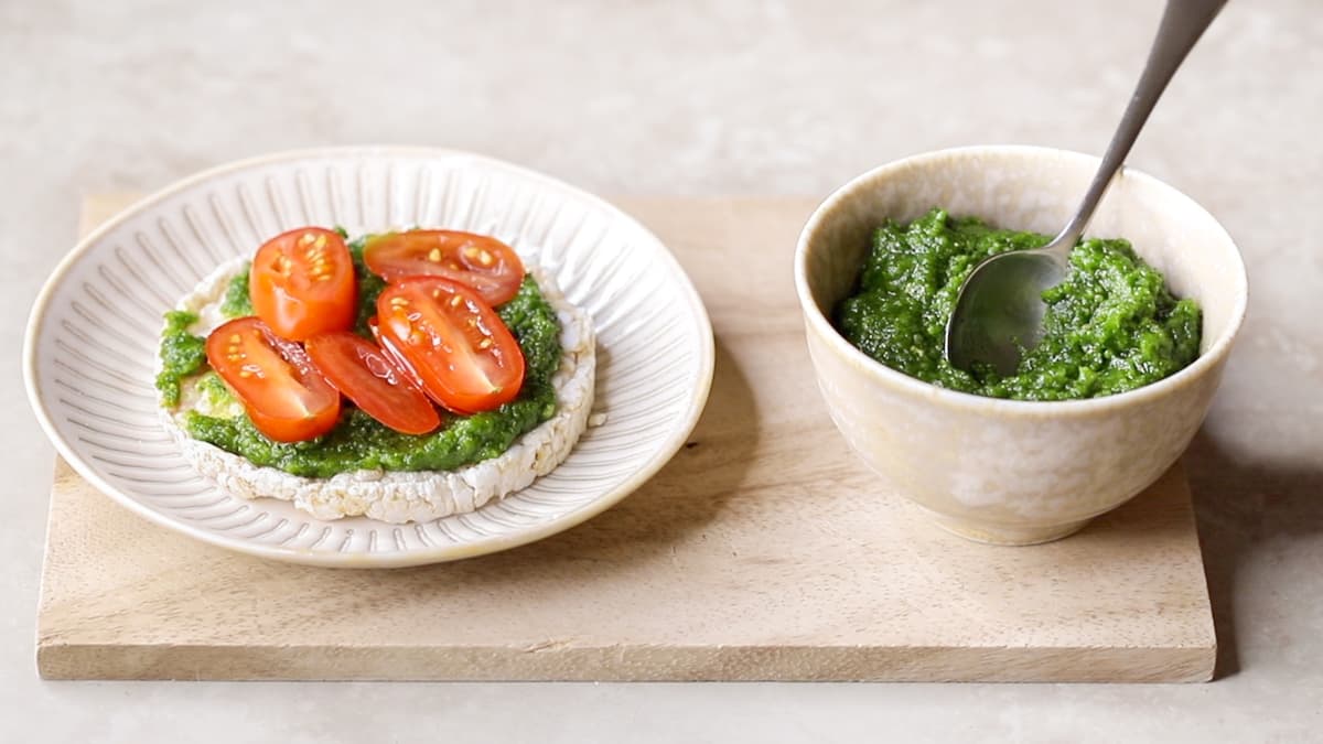 Rice cake topped with parsley pine nut pesto and sliced grape tomatoes