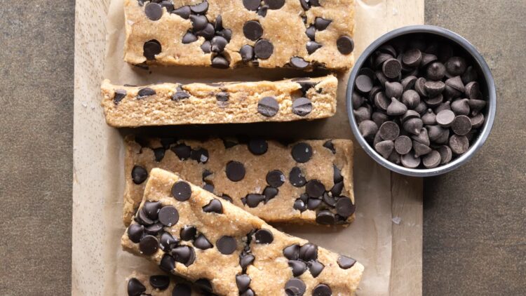 Chewy chocolate chip oat protein bars arranged on a wooden board