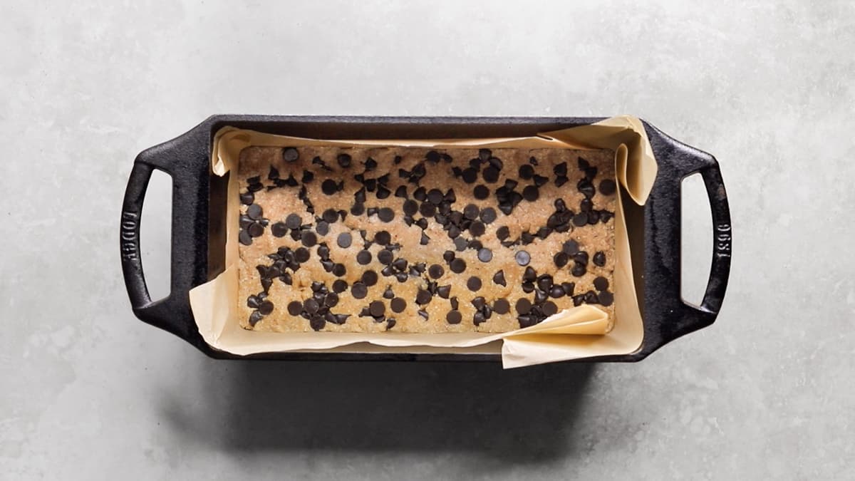 Chocolate chip protein bar dough pressed into a loaf pan