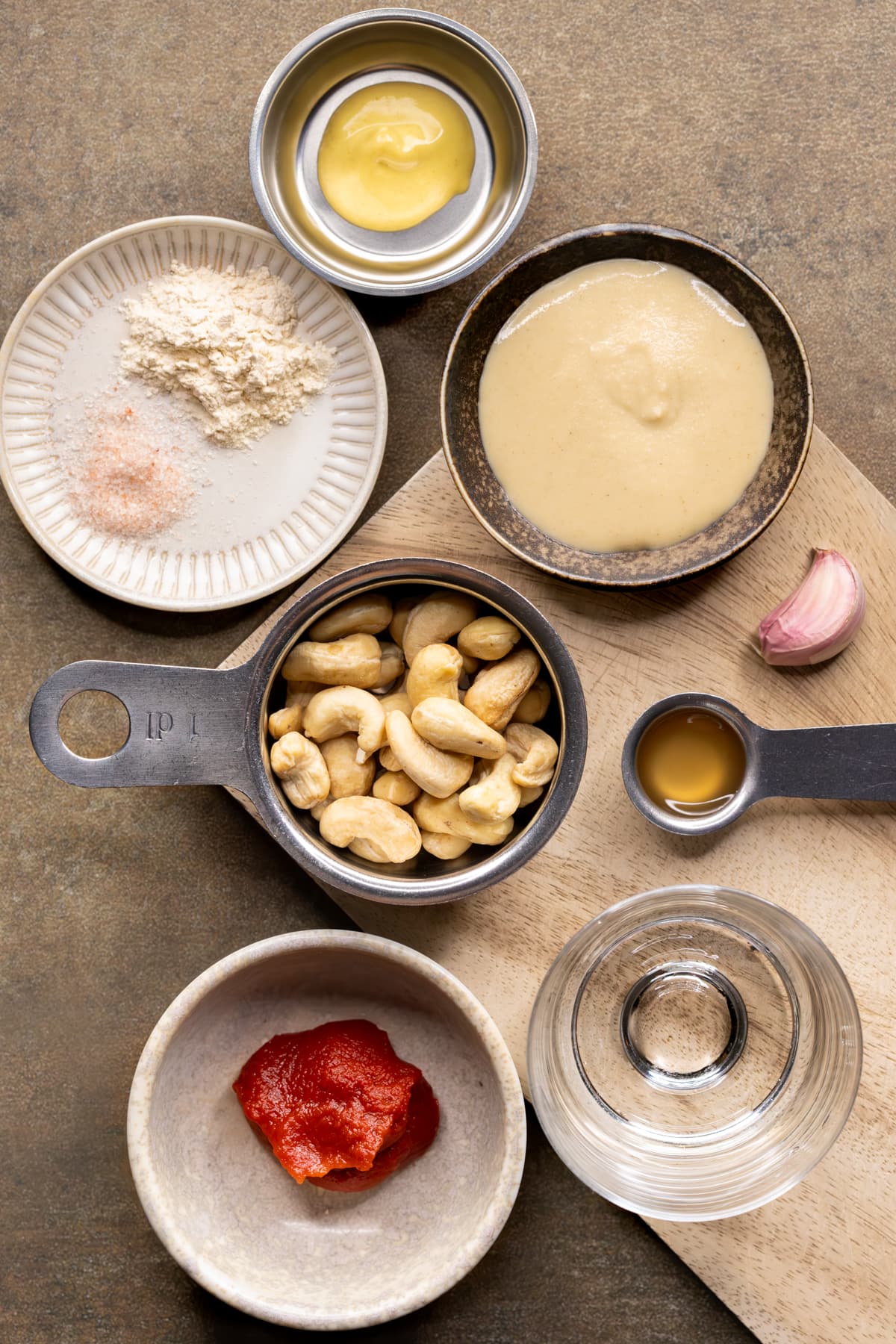 Ingredients for homemade vegan burger sauce set out on a wooden board