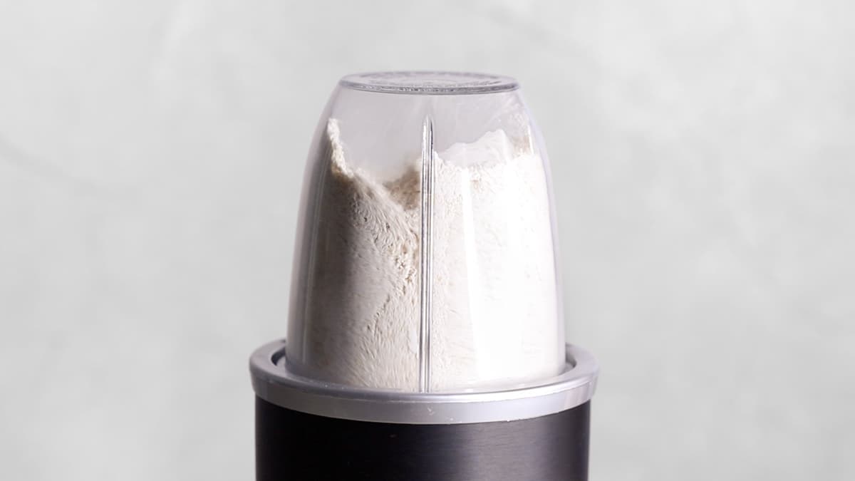 Oats being processed in a blender to make oat flour for protein bars
