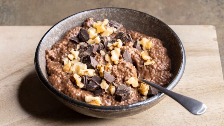 Quick chocolate brownie batter chia pudding in a bowl on a wooden board