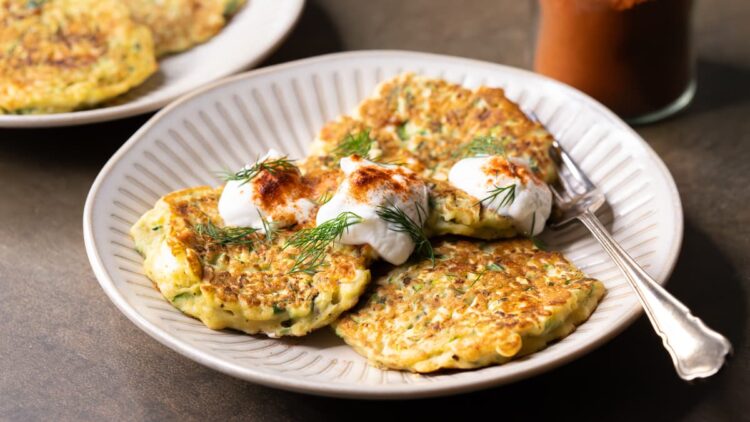 Gluten-free zucchini fritters with feta, yoghurt and fresh dill on a plate