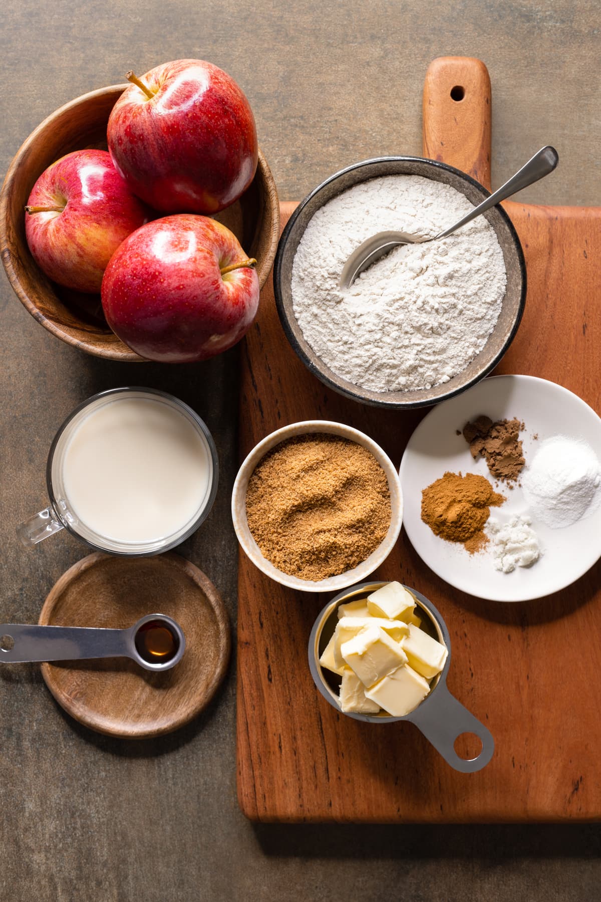 Ingredients for gluten-free apple cake set out on a wooden board
