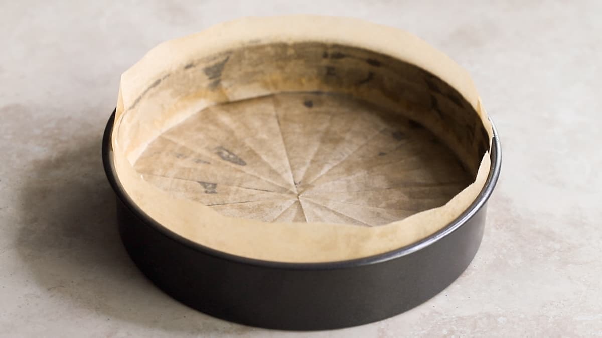 Line a round cake tin with baking paper