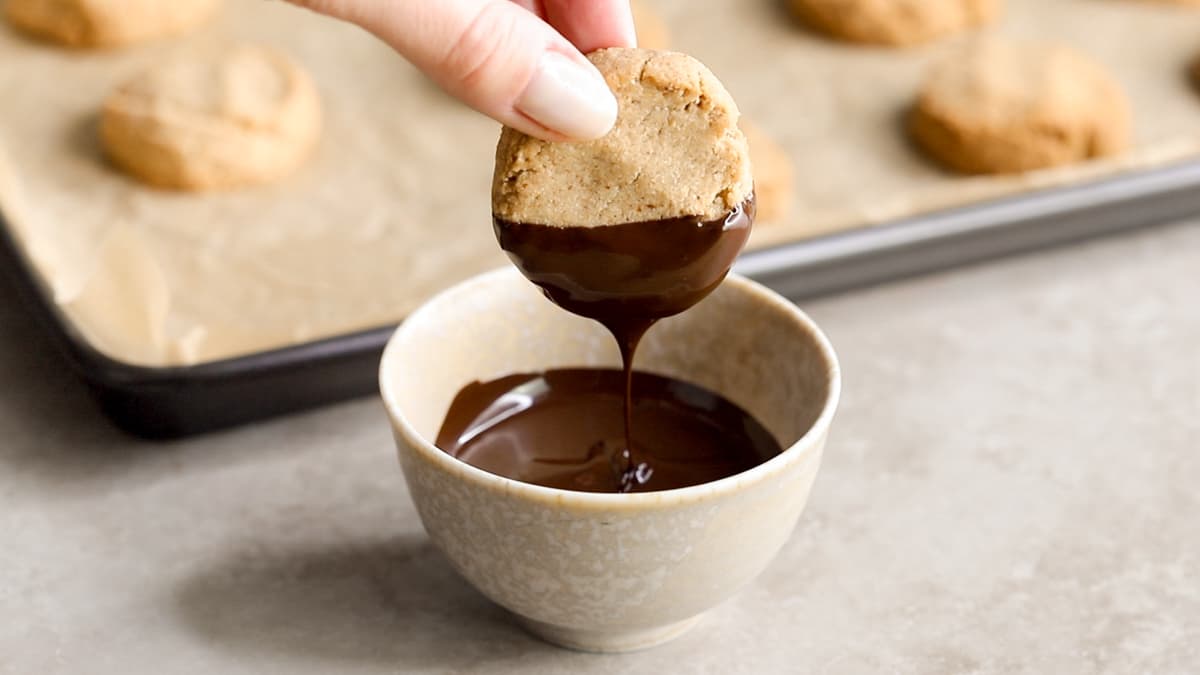 Almond olive oil shortbread cookies being dipped in chocolate