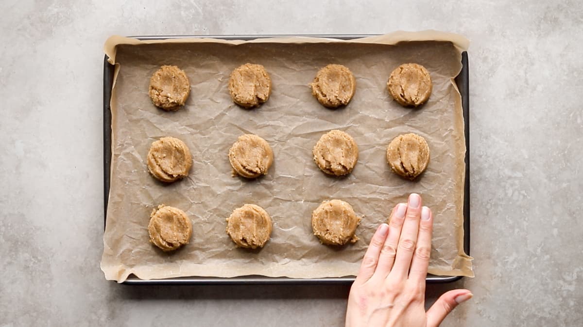 Twelve almond olive oil shortbread cookies shaped and placed on a lined baking tray