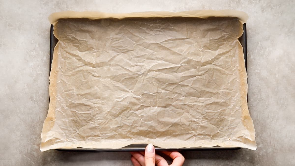 Baking tray lined with non-stick baking paper, ready for cookies