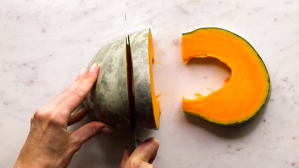 Pumpkin cut into thick slices on chopping board