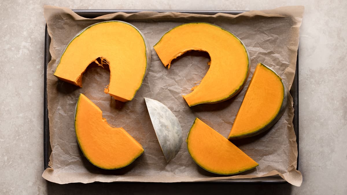 Pumpkin slices arranged flat on lined baking tray
