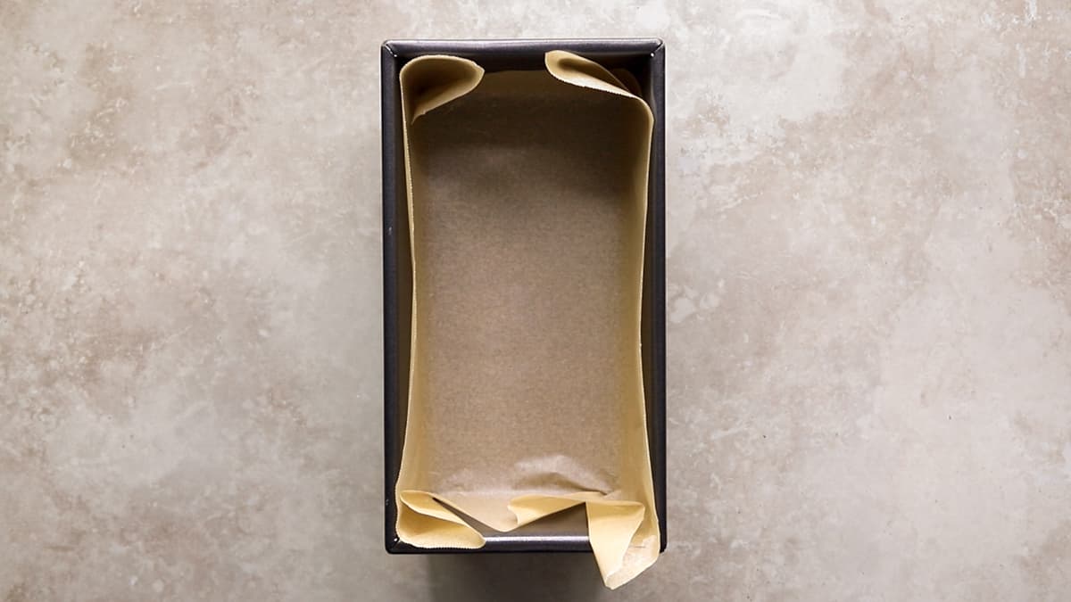 Loaf pan lined with baking paper, ready for cake batter