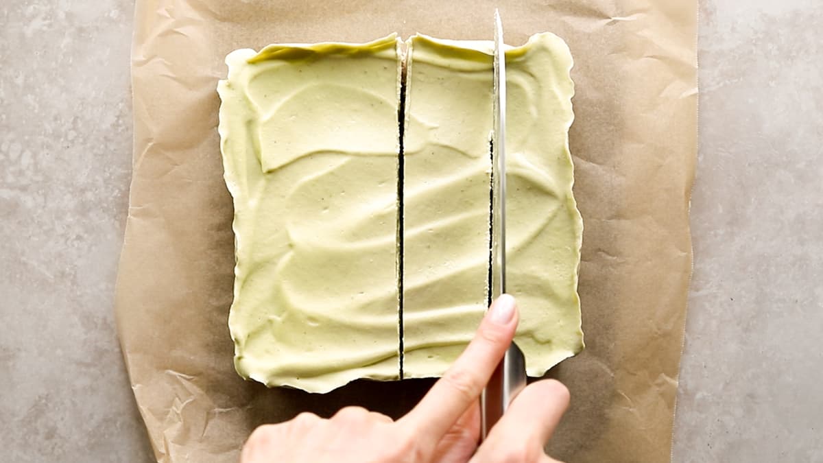 Cutting no-bake vegan lime cheesecake into slices