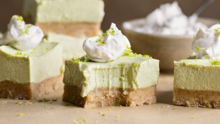 No-bake vegan lime cheesecake bars topped with coconut cream and lime zest