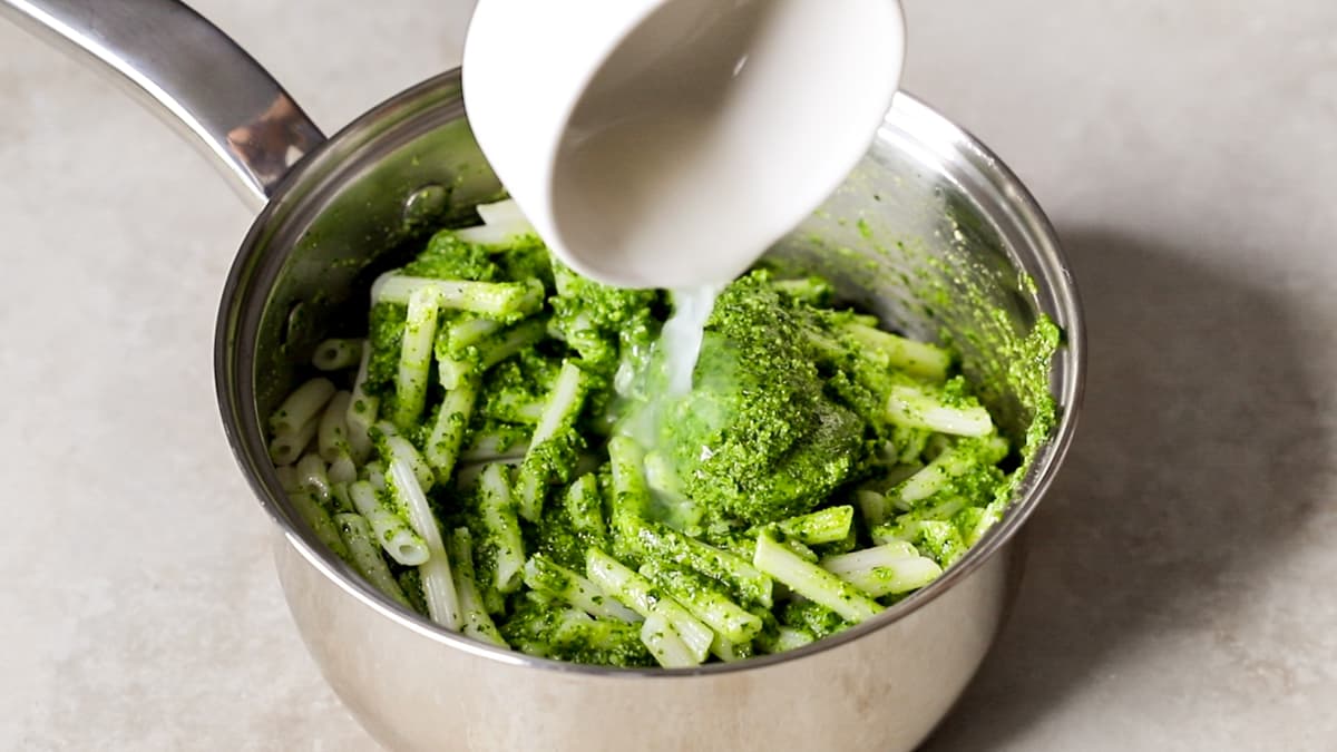 Use the saved cooking water to loosen the pesto sauce