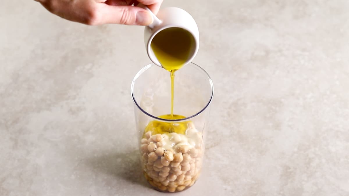 Add the hummus ingredients to a hand blender cup
