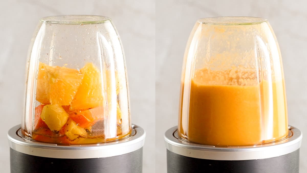Orange, carrot, ginger, turmeric, cinnamon, and water in a blender being blended into a smoothie