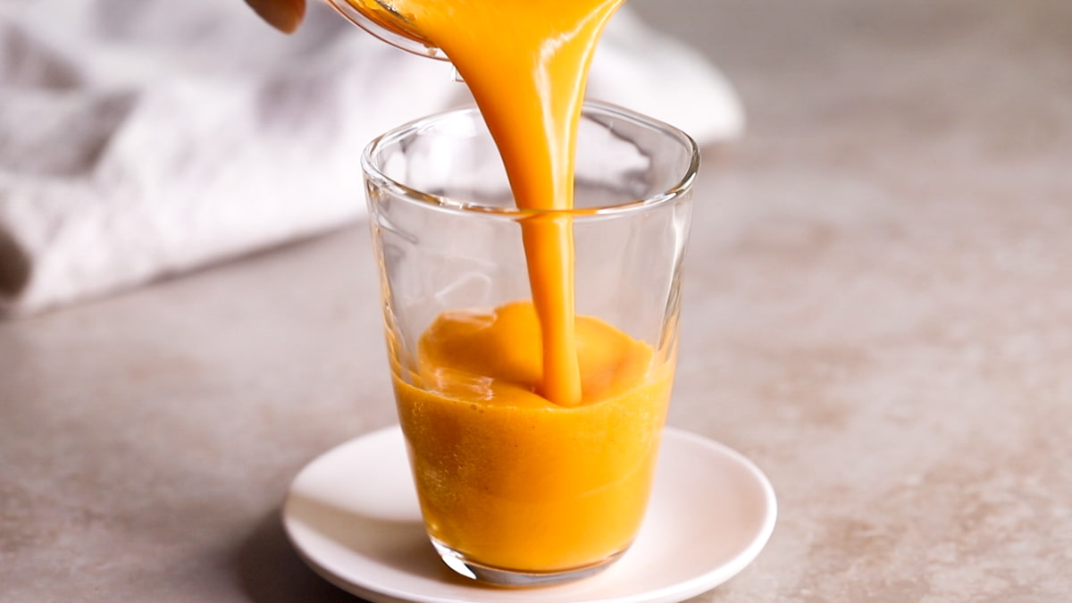 Orange Ginger Carrot Smoothie being poured into a glass