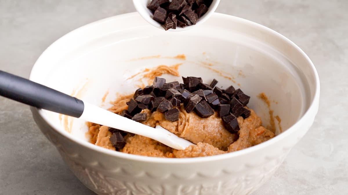 Vegan sweet potato bread batter with dark chocolate chips in a bowl