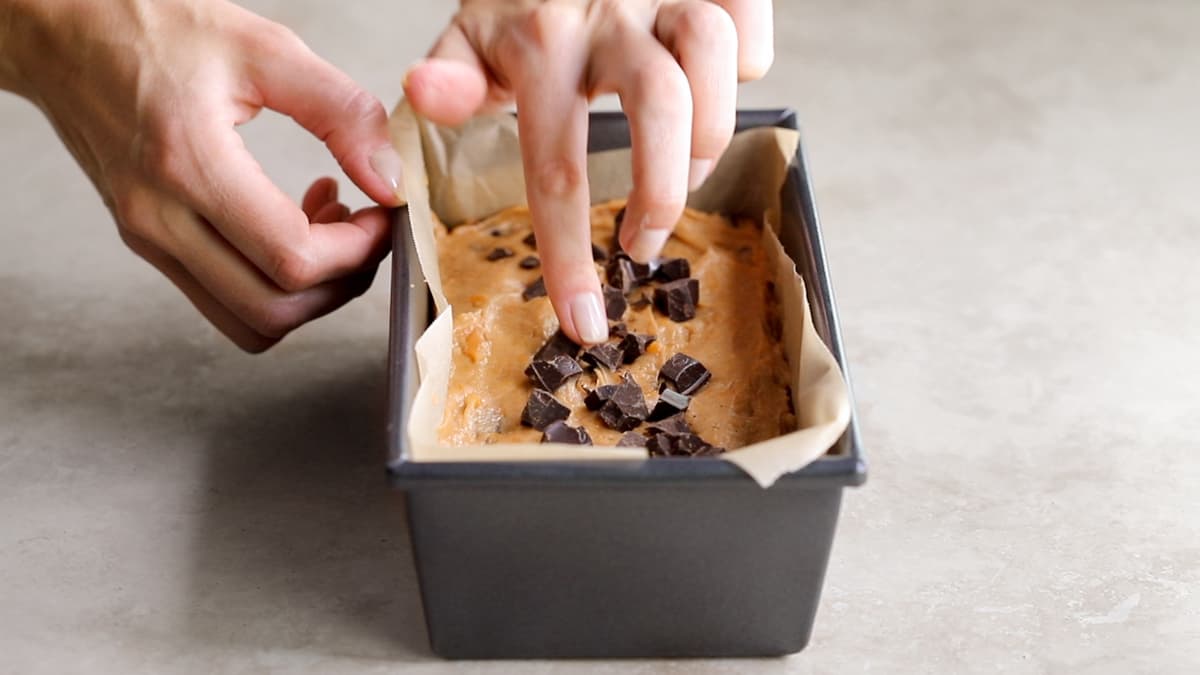 Vegan sweet potato bread batter with dark chocolate chips in a loaf pan