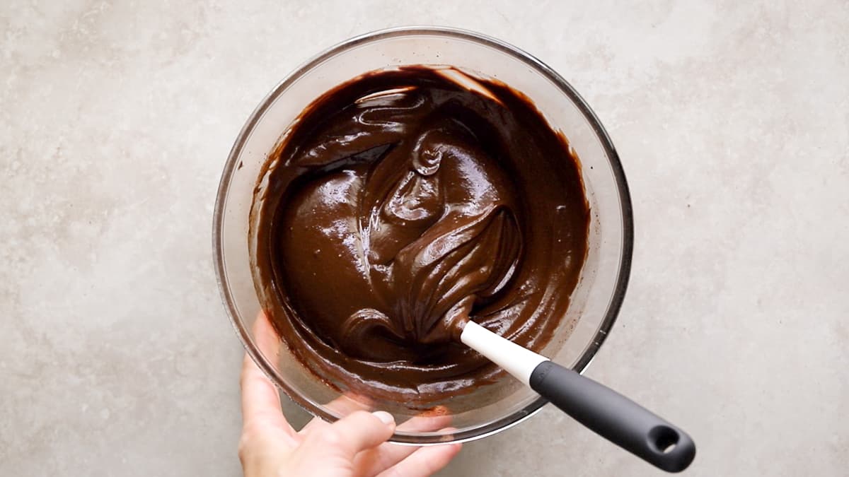 Smooth chocolate fudge frosting in a mixing bowl