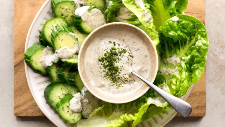 Creamy vegan tahini ranch dressing served in a bowl with raw green vegetables