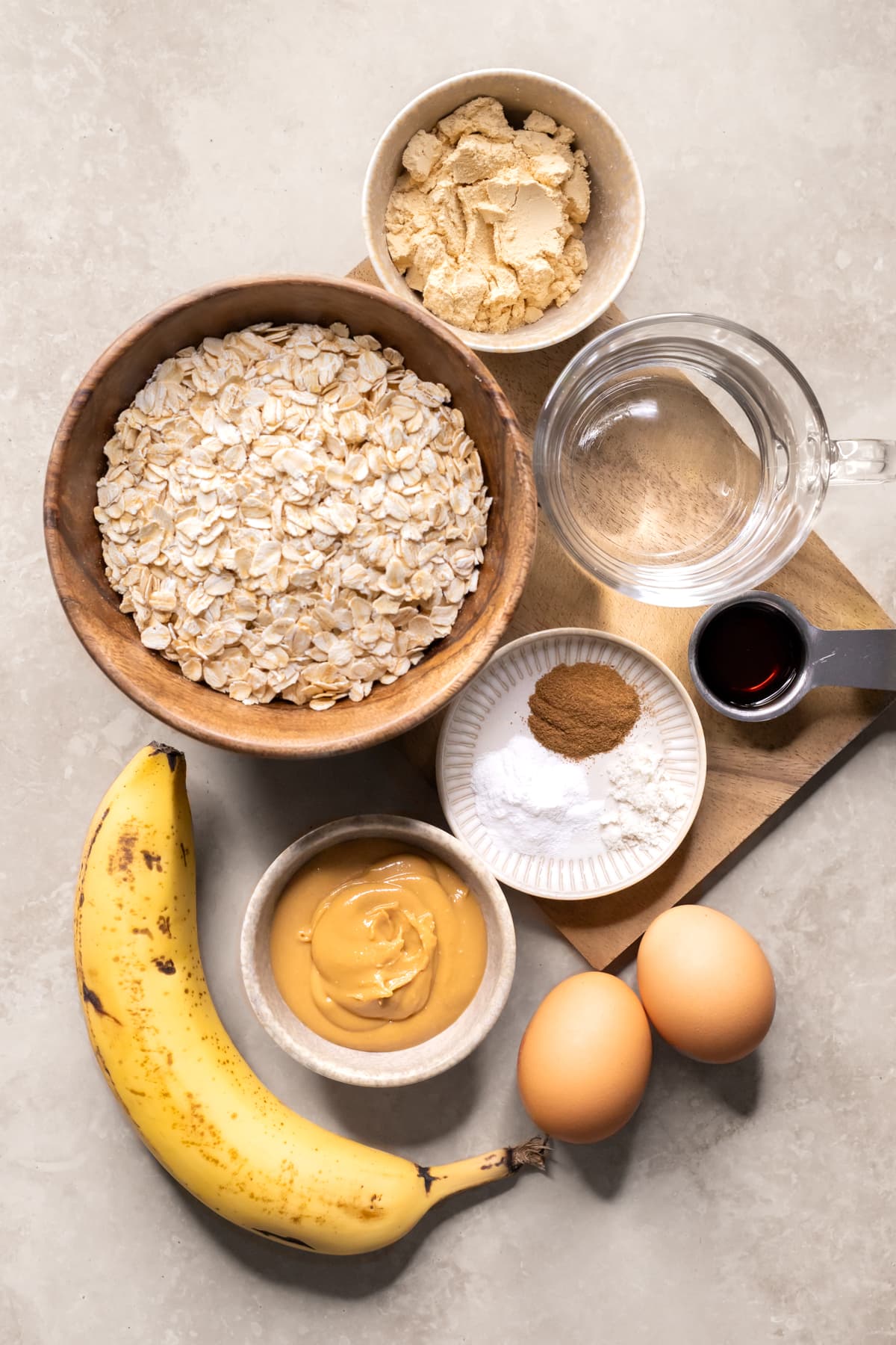 Ingredients for banana cinnamon baked oatmeal protein bars set out in bowls