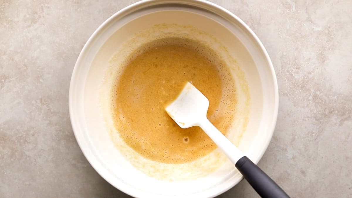 Mashed banana and egg whites being mixed with peanut butter in a bowl