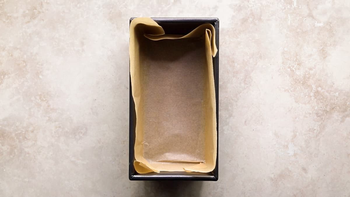 Loaf tin lined with baking paper, ready for the oatmeal mixture to be added