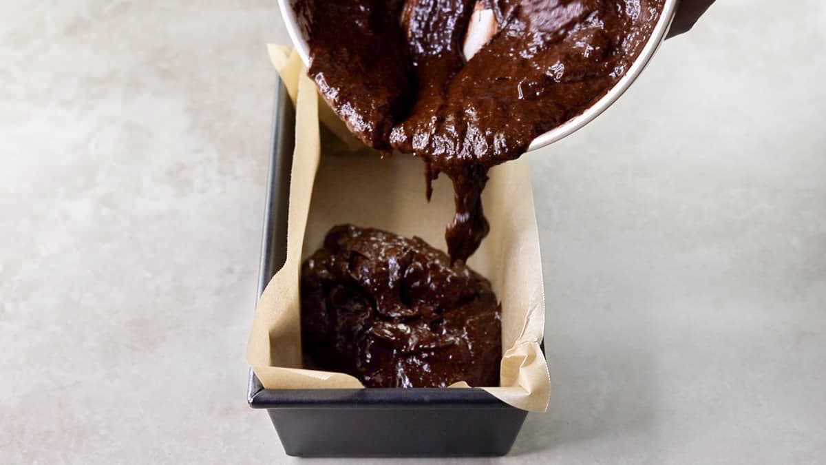 Tip the zucchini brownie batter into the loaf tin