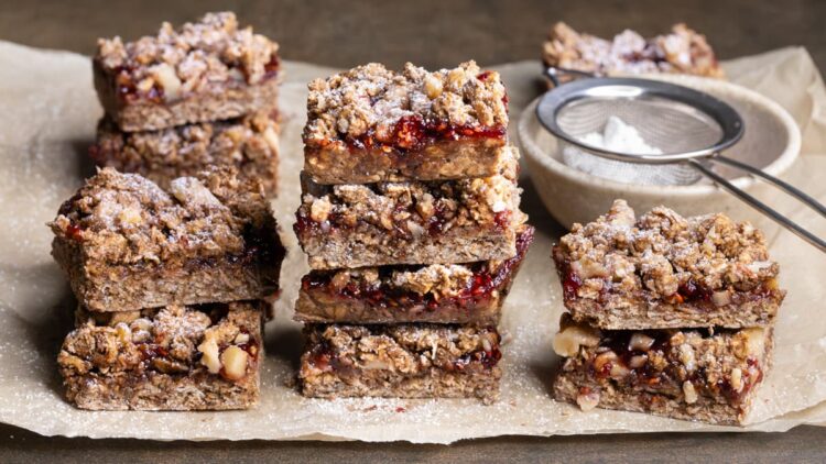 Oatmeal crumble bars arranged in stacks and dusted with powdered sugar