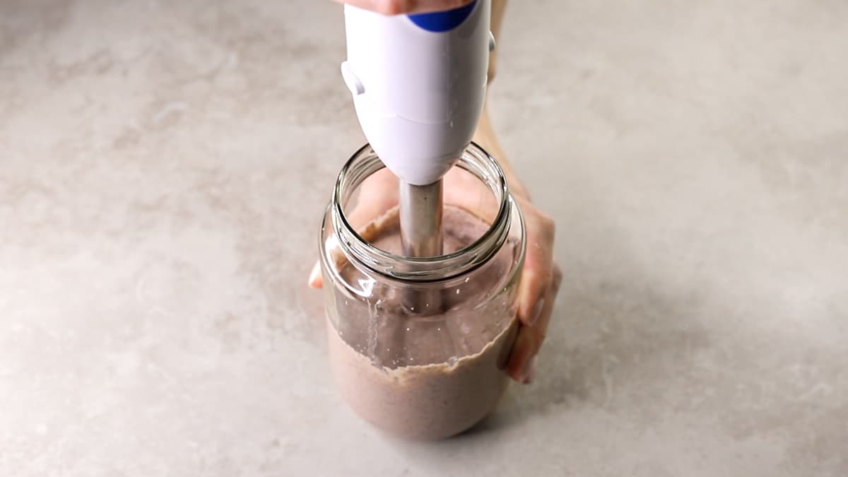Black bean dip being blended with a hand blender