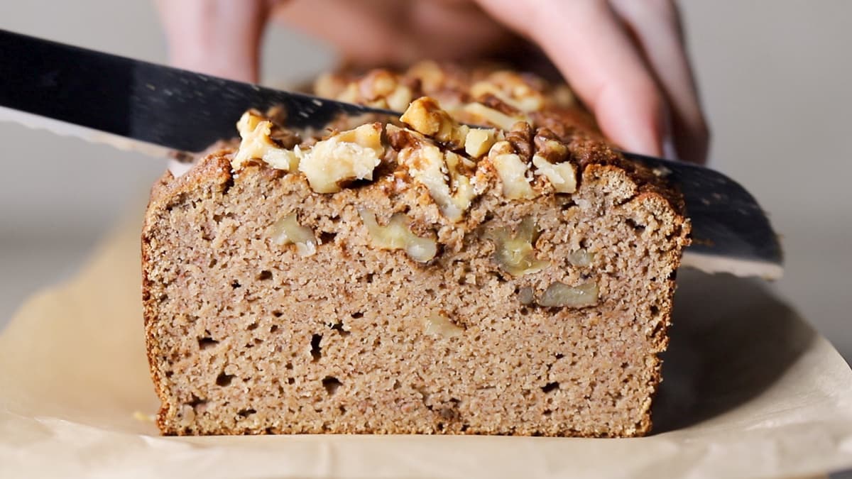Coconut flour banana bread topped with chopped walnuts