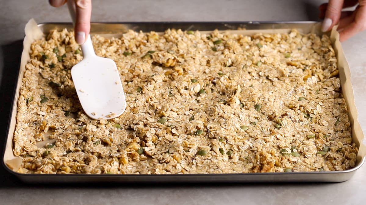 Press the granola mixture onto the lined baking sheet