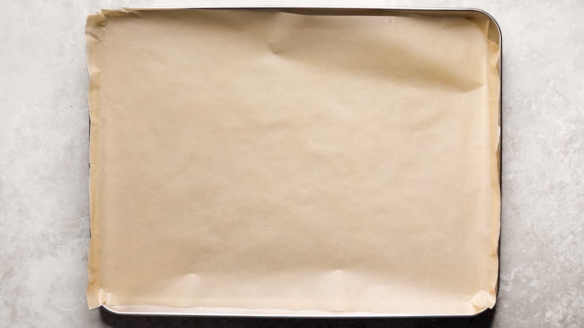 Baking sheet lined with parchment paper ready for cookies