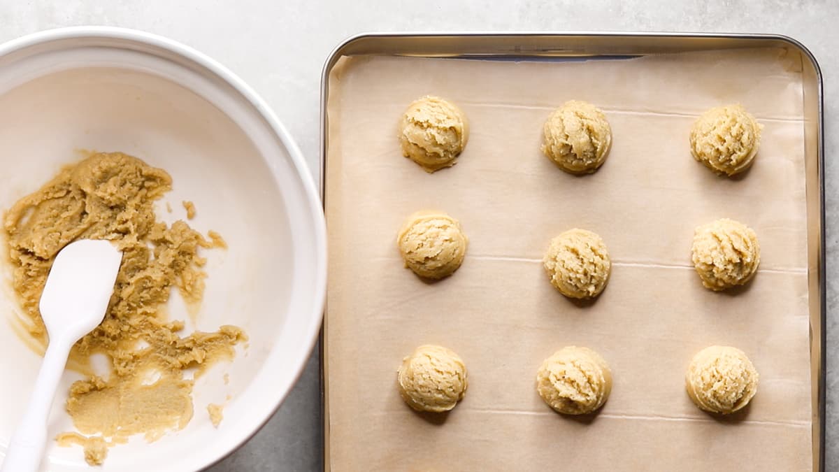 Portioned gluten-free lemon shortbread cookie dough balls on a baking sheet ready to bake