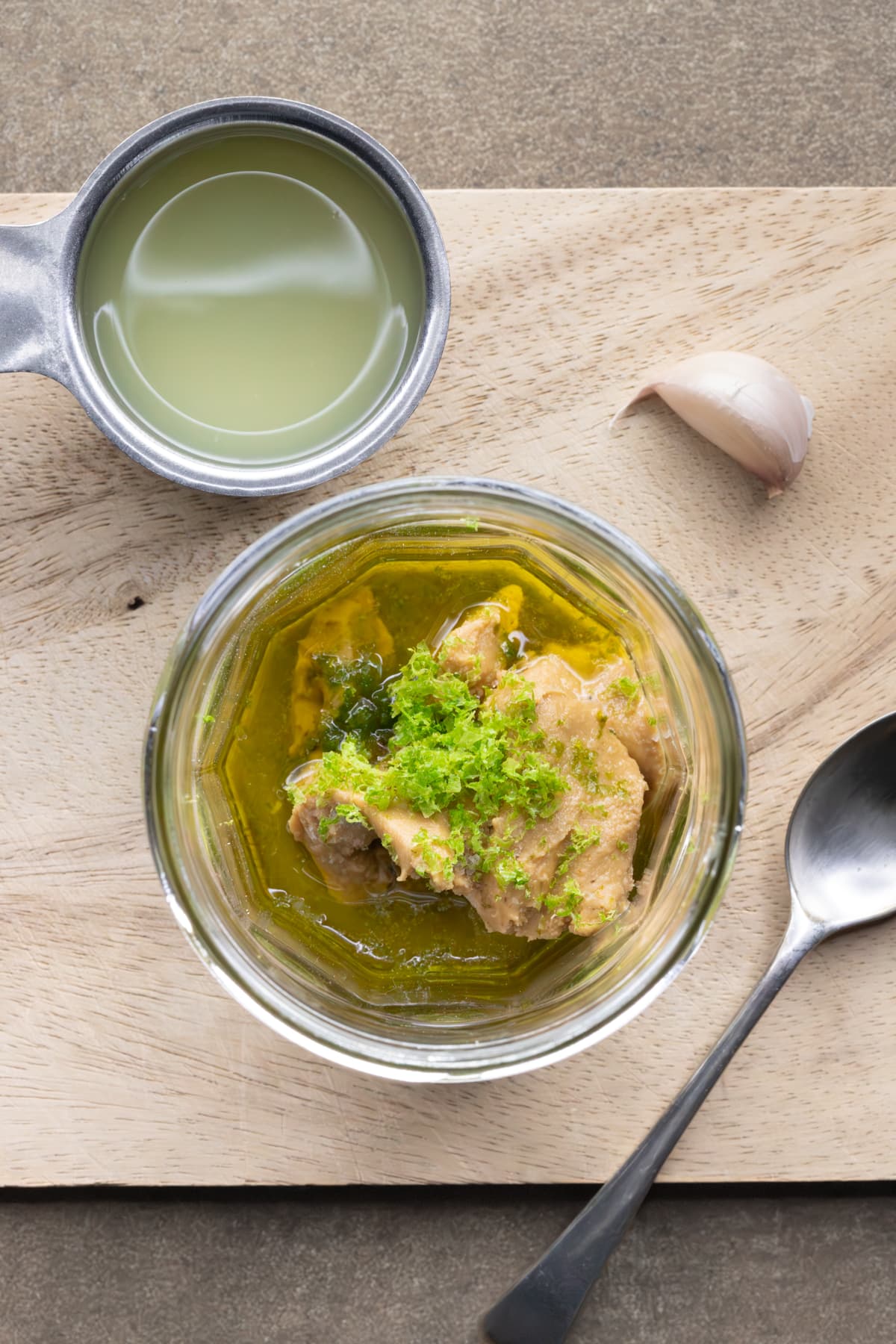 Cashew lime salad dressing ingredients including cashew butter, lime zest, lime juice and garlic