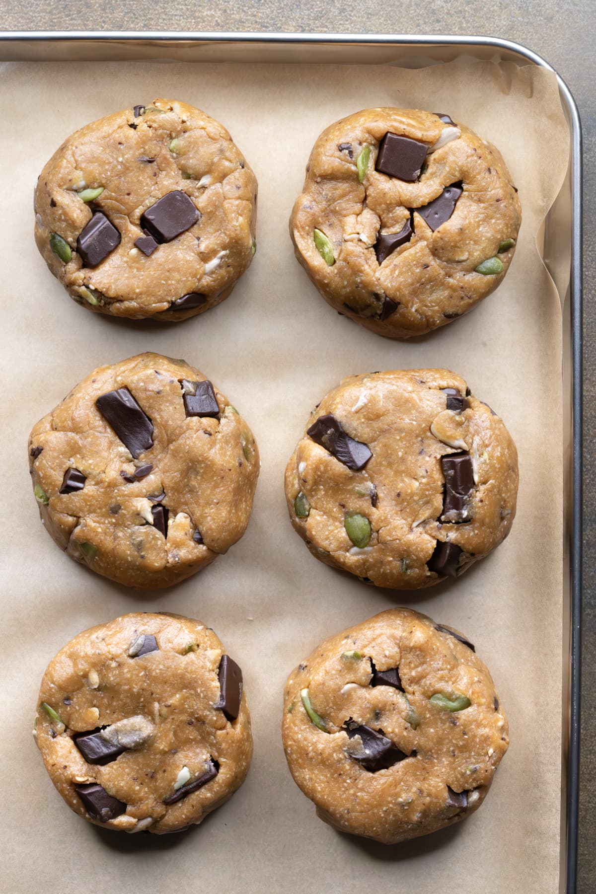 Thick chocolate chip cookie dough on a baking sheet