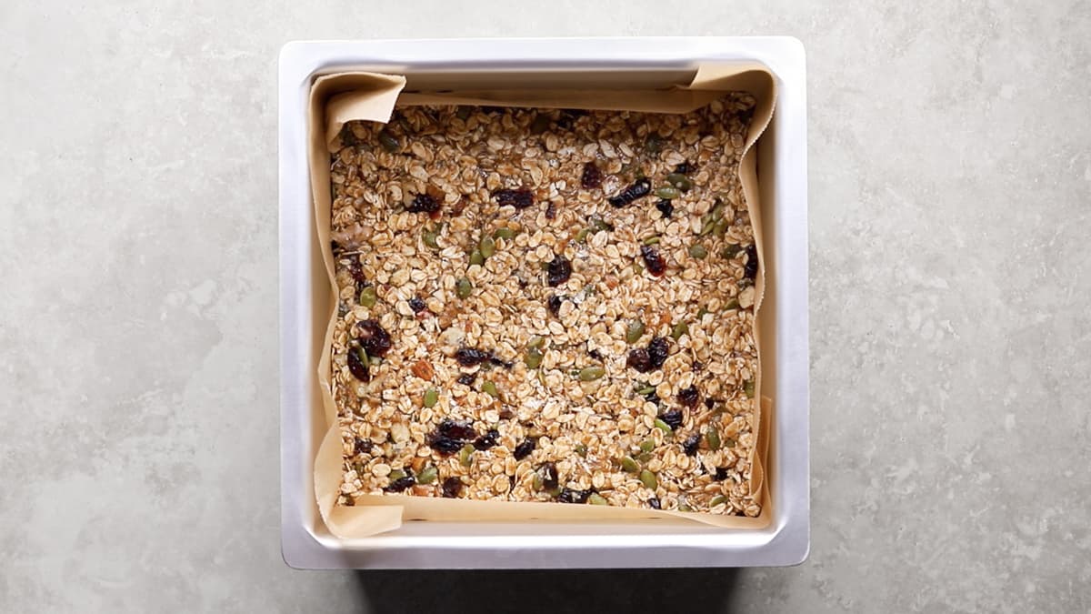 Press the granola bar mixture firmly into a square pan