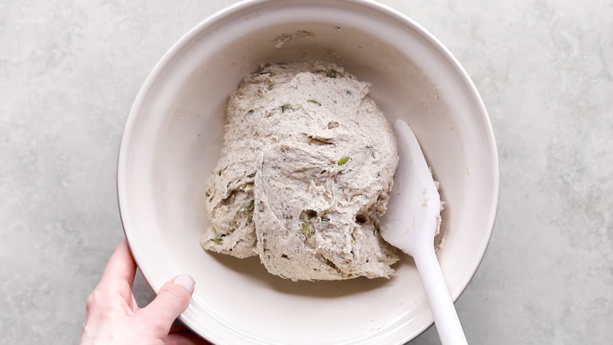 Bread dough in a mixing bowl with a spatula
