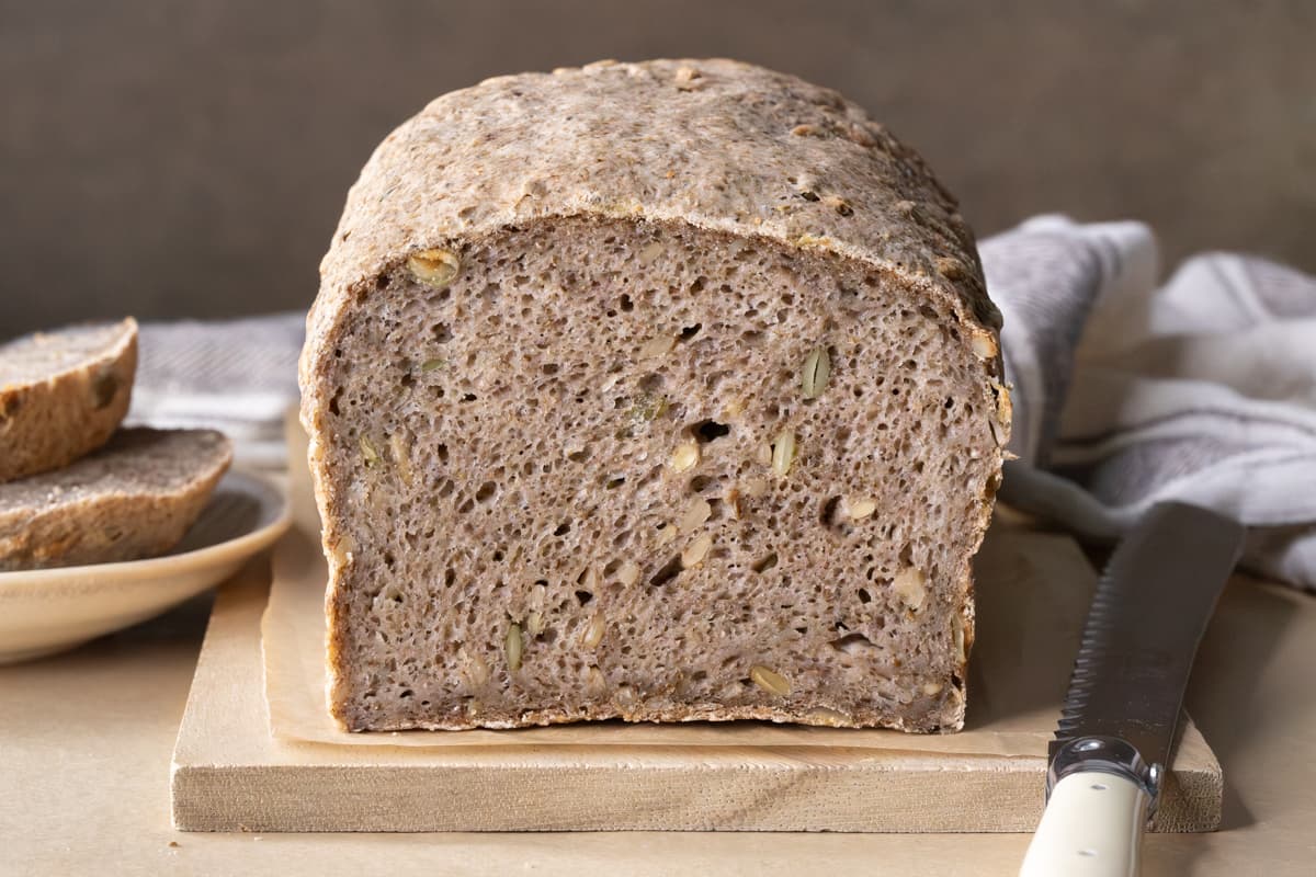 A loaf of gluten-free buckwheat bread cut to show crumb texture