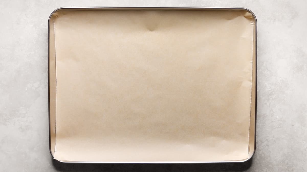 Empty baking sheet lined with parchment paper ready for baking