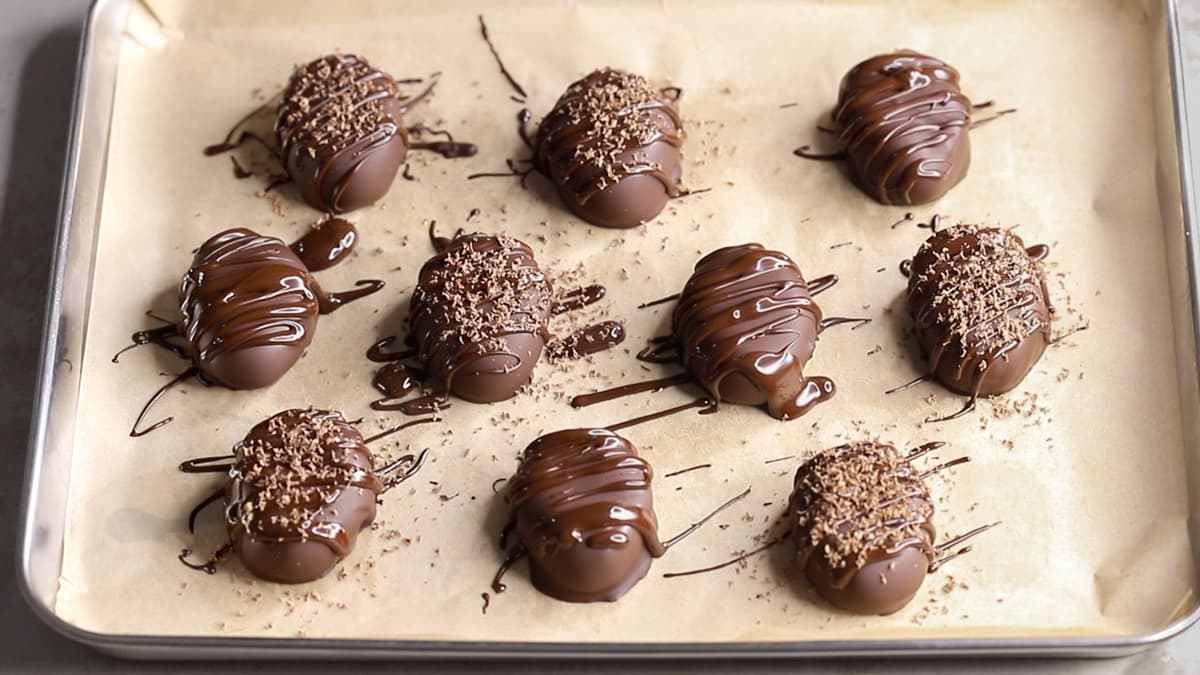 Decorated chocolate almond butter Easter eggs on a parchment-lined tray, ready to chill and set