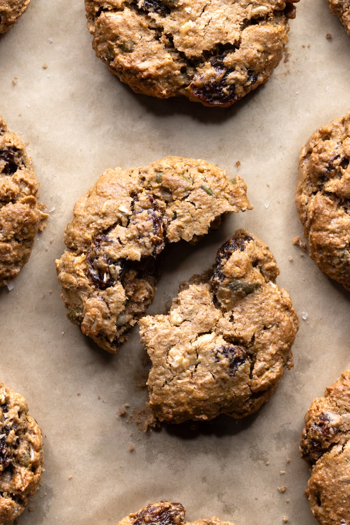 Two halves of a flourless oatmeal raisin cookie showing a chewy interior with visible raisins