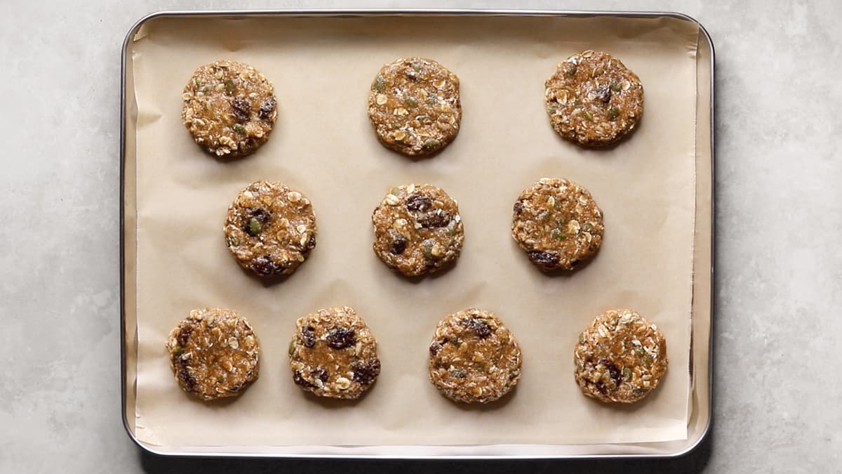 Oatmeal raisin cookie dough shaped into individual portions on a baking sheet, ready to bake