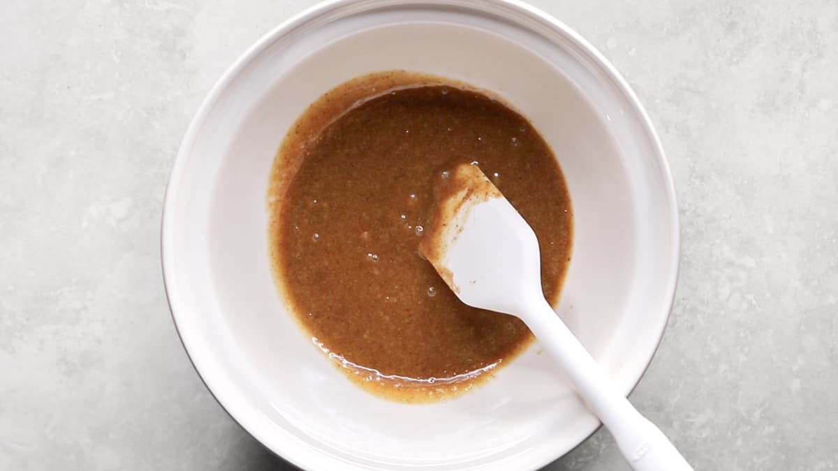 Wet ingredients for oatmeal raisin cookies mixed together in a bowl, ready to combine with dry ingredients